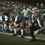 Generate a high-definition, realistic image showcasing a tense scene in sports coaching. Visualize a soccer field with players waiting in anticipation. Next to them, there's a middle-aged Caucasian male coach, furrowing his brow, trying to calm a situation. He's ignoring a potentially controversial comment made by a player, choosing instead to focus on the game. On the bleachers, a diverse crowd of spectators watches on with mixed reactions, conveying the moment's tension.